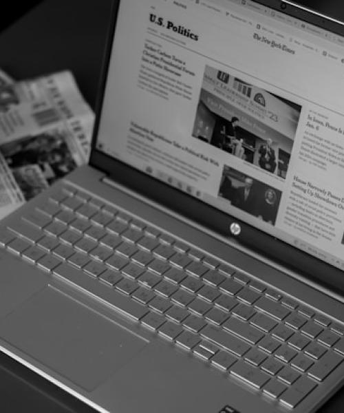 Krant en laptop als symbool voor de link tussen earned media, digitale zichtbaarheid en AI-antwoorden – Charly PR