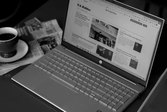 PR zichtbaar maken in media én AI Laptop en krant illustreren hoe thought leadership en earned media doorwerken in zoekmachines en AI-antwoorden – Charly PR